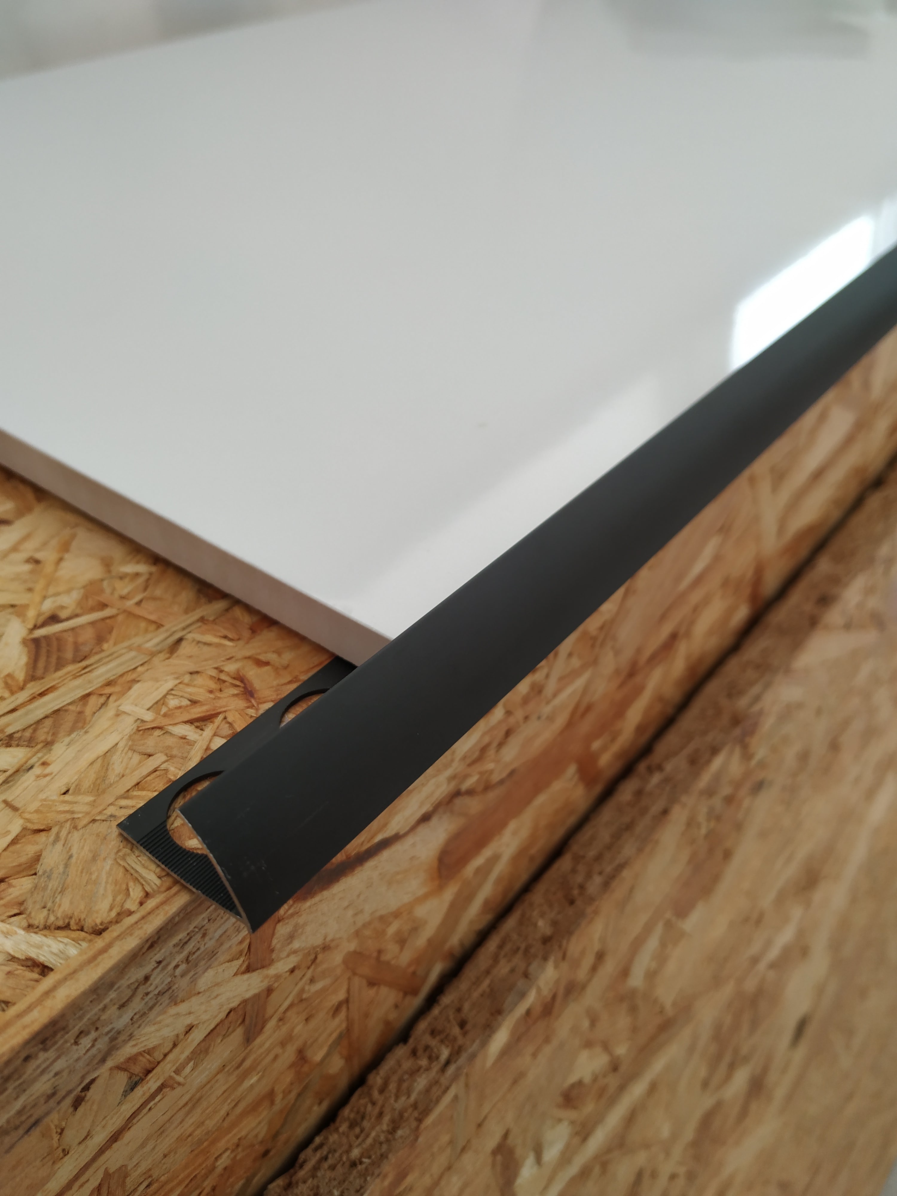 Perfil Jolly preto, acabamento elegante e resistente para revestimentos cerâmicos e pavimentos.