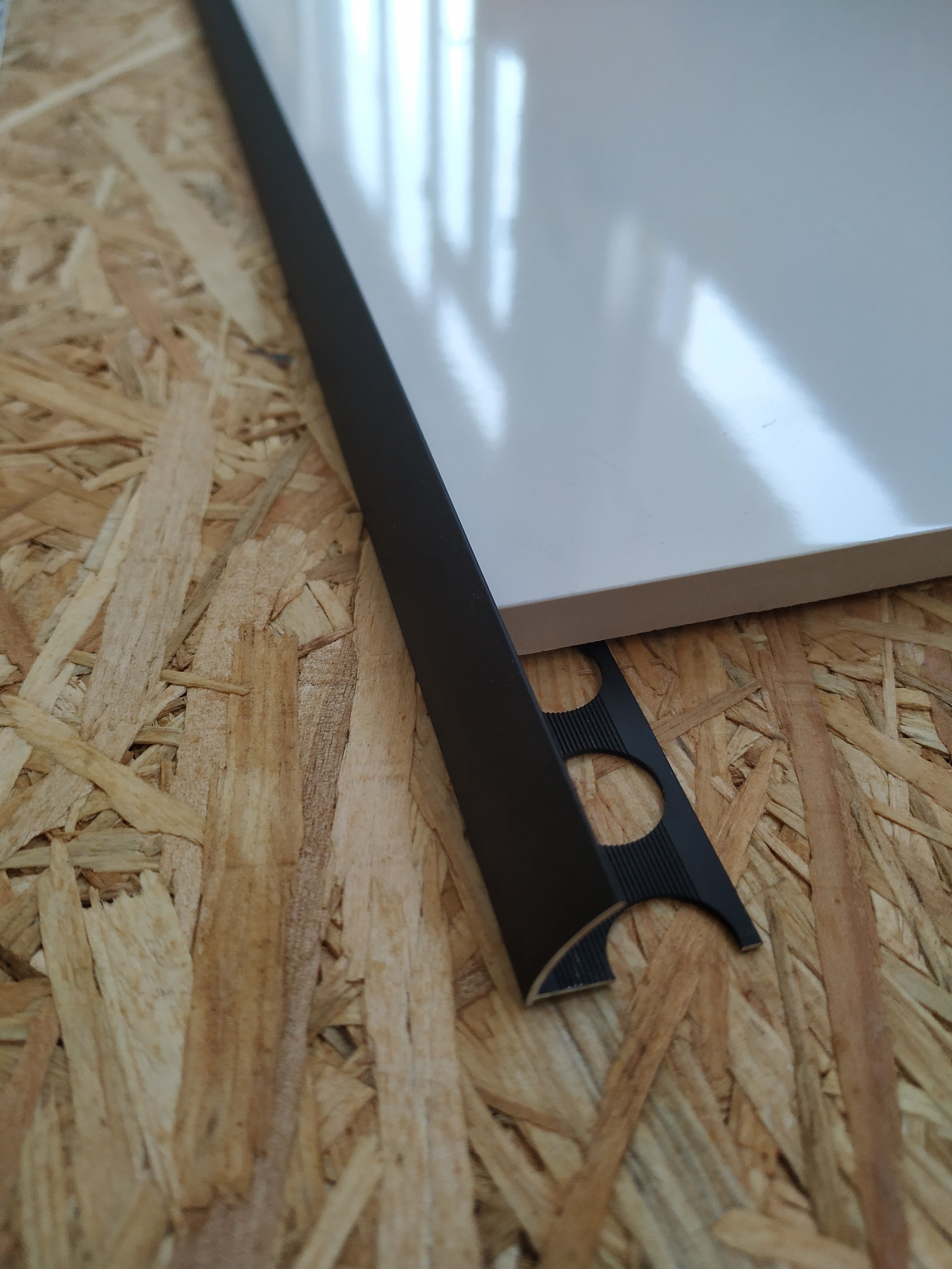 Perfil Jolly preto, acabamento elegante e resistente para revestimentos cerâmicos e pavimentos.